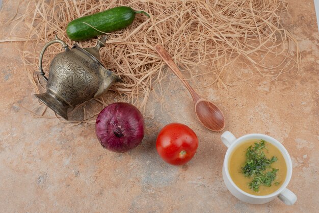 Fresh vegetables with delicious soup on marble surface