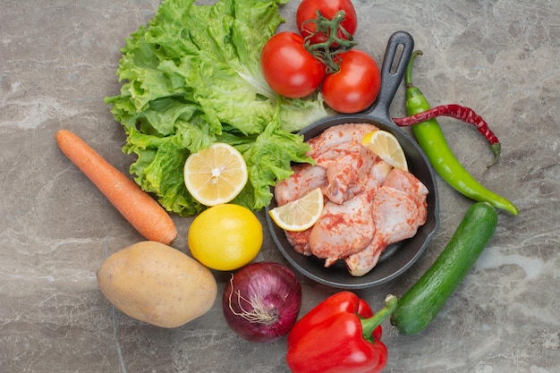 Free photo fresh vegetables with raw chicken on marble background. high quality photo