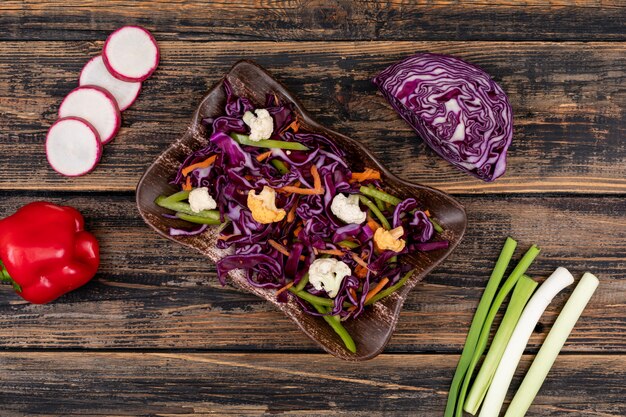 свежий витамин фитнес салат из красной капусты в тарелке на деревянном