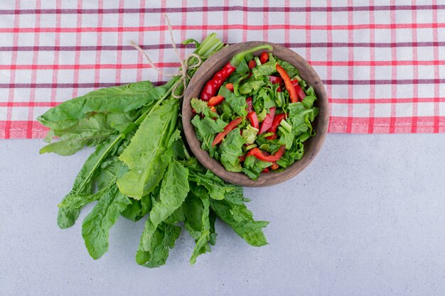 Fresh watercress leaves and a bowl of salad on marble background. High quality photo