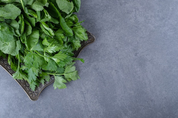 Fresh watercress on a tray, on the marble surface.