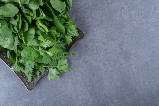Fresh watercress on a tray, on the marble surface.