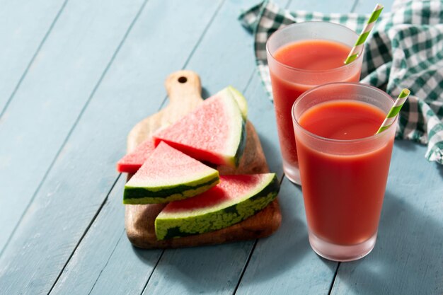 Fresh watermelon juice with ice on blue wooden table