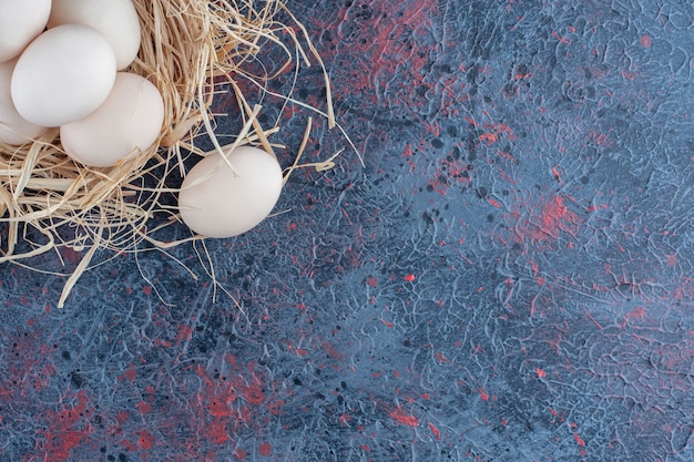 Fresh white and brown chicken eggs with hay 