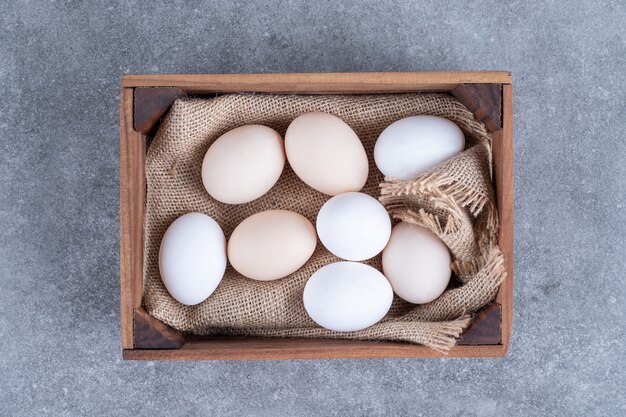 Fresh white chicken eggs on a wooden basket