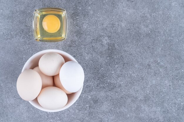 Fresh white raw chicken eggs on a white plate