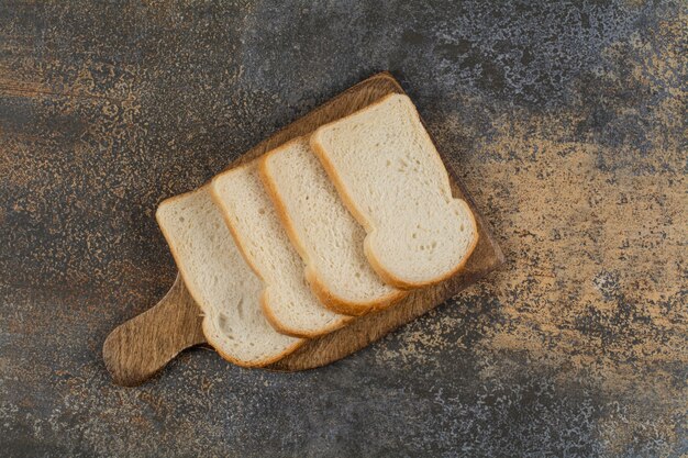 Fresh white sliced bread on wooden board.