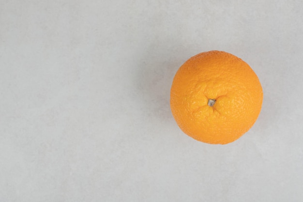 Fresh whole orange on gray surface