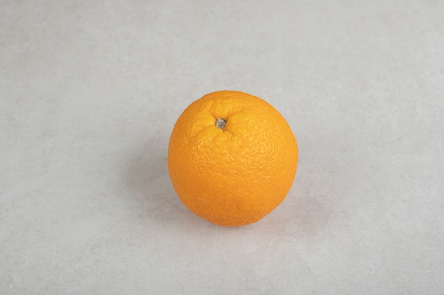 Fresh whole orange on gray surface