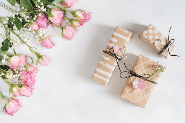 Fresh wonderful roses near present boxes and petals