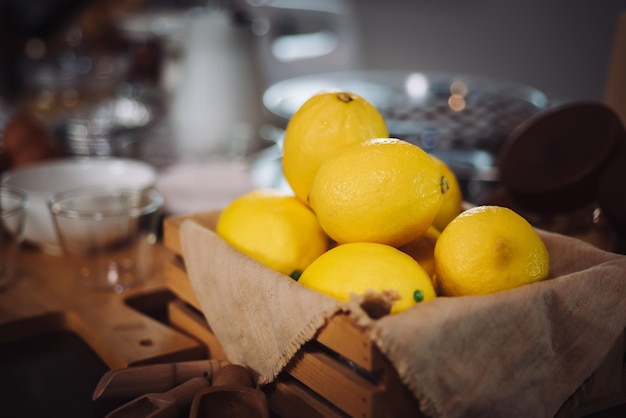 Свежие желтые органические лимонные фрукты на фоне старинного деревянного стола