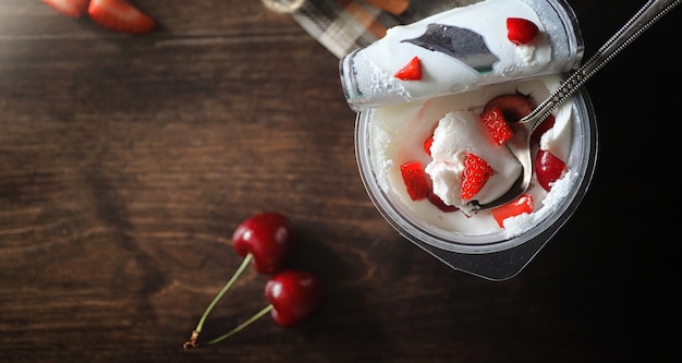 Свежий йогурт с ягодами. мороженое в миске со свежей и сочной клубникой и вишней. десерт с красными ягодами.