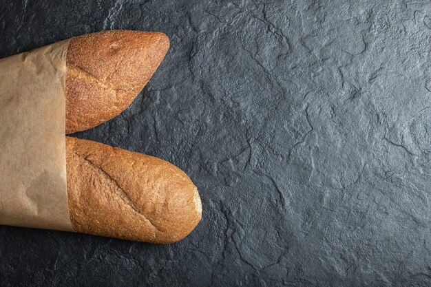 Свежеиспеченный хлеб буханки британской дубинки на черном фоне.