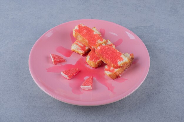 Freshly baked cake and grapefruit slices on pink plate