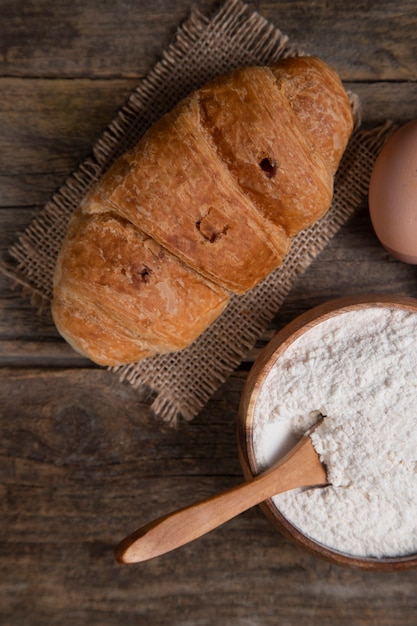 Freshly baked croissant with chicken egg and flour . High quality photo