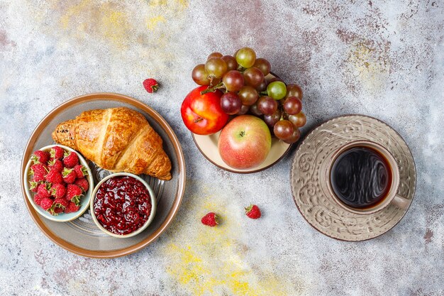 Freshly baked croissants with raspberry jam and raspberry fruits.