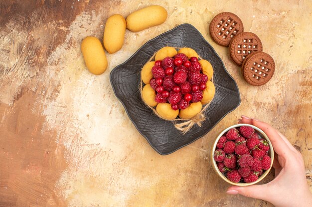 Freshly baked gift cake on a brown plate biscuits and fruit plate on mixed color table