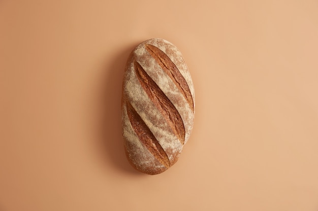 ベージュの背景の上に分離された焼きたての自家製の長いパン。白小麦パンを作るには、小麦粉、塩、酵母などのさまざまな材料が必要でした。ベーキングの概念。食べるのに必要な商品