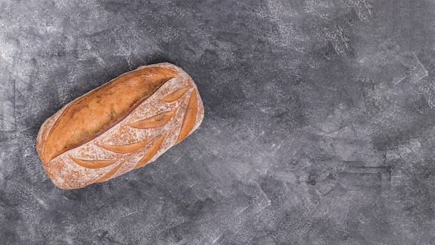 Свежеиспеченный кусок хлеба на черном фоне текстурированных