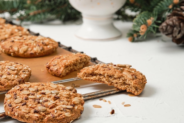 Freshly baked oatmeal cookies with sunflower seeds are cooling on a tray The concept of simple homemade baking for the new year or Christmas the idea of a healthy diet Closeup soft focus