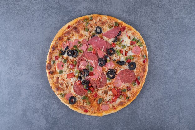 Freshly baked pepperoni pizza on grey background.