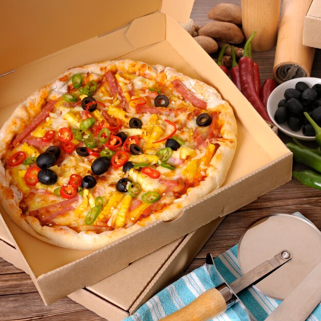 Freshly baked Pizza in delivery box with ingredients.