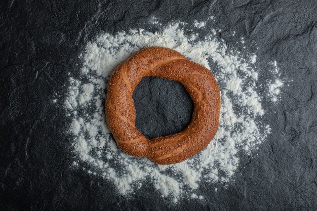 Freshly baked Turkish simit on black background.