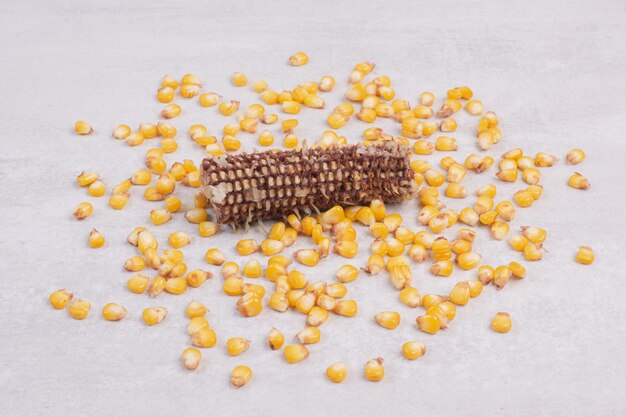 Свежевываренные семена кукурузы на белом столе.