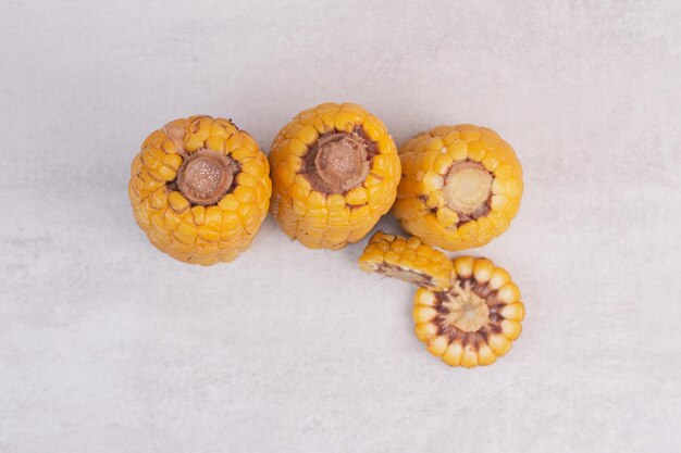 Freshly boiled corns on white table.