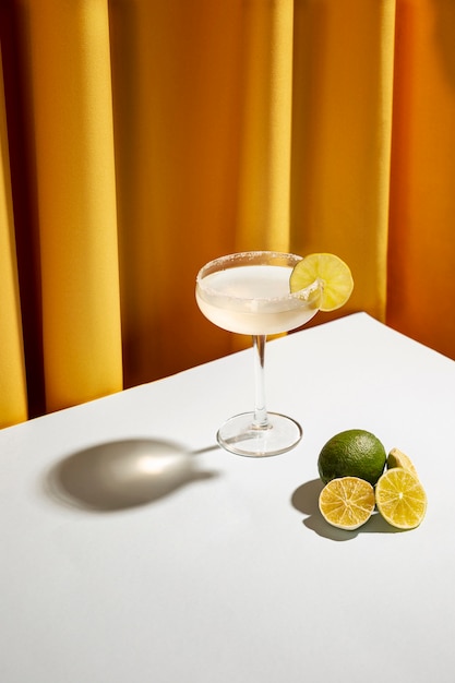 Freshly cocktail drink with salty rim and lemon slices over white desk