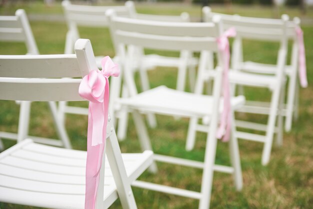 椅子に新鮮なカットの美しい赤と紫の結婚式の花の花輪。