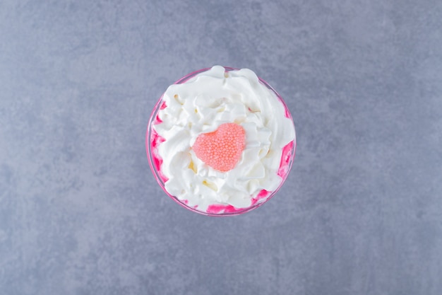 Free photo freshly made creamy pink milk shake on grey background.