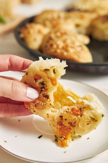 Freshly-made delicious cheese bubble pizza bread with ingredients and cheese on a white table