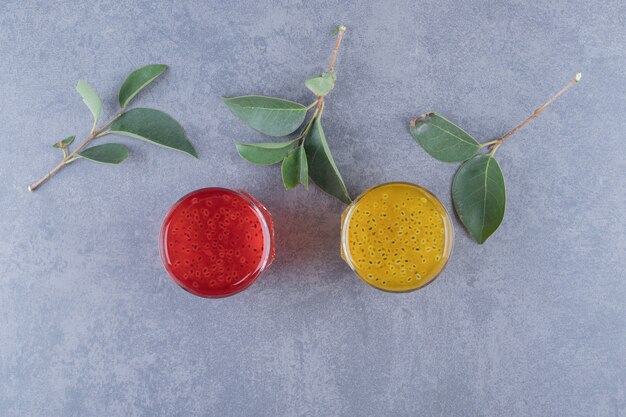 Freshly made orange and pomegranate juice on grey background.