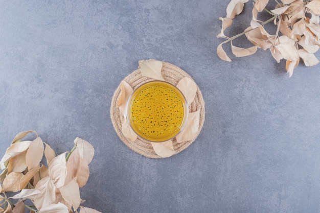 Freshly made tangerine juice on wooden board over grey background.