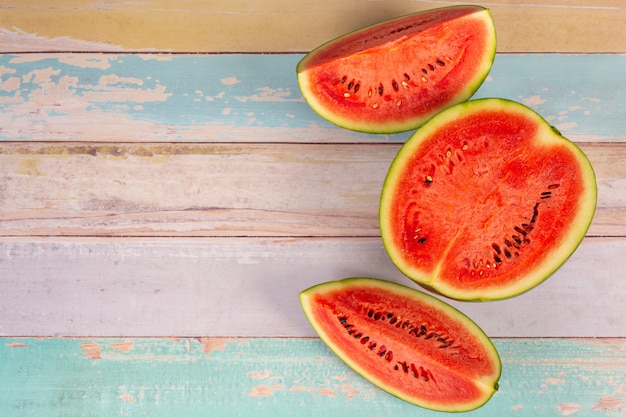 Freshly sliced red watermelon on a wooden board wall