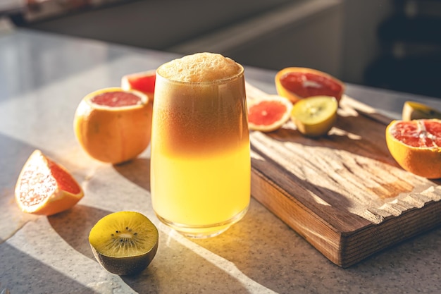 Free photo freshly squeezed juice in a glass and fresh fruit on the kitchen table