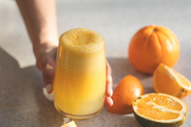 Free photo freshly squeezed orange juice in female hands close up