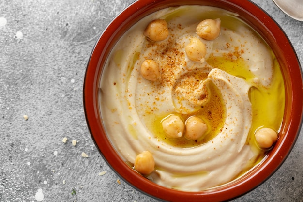 Freshmade oriental classic hummus served in bowl on the table.