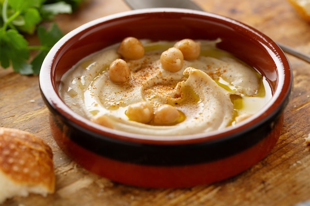 Freshmade oriental classic hummus served in bowl on the table.