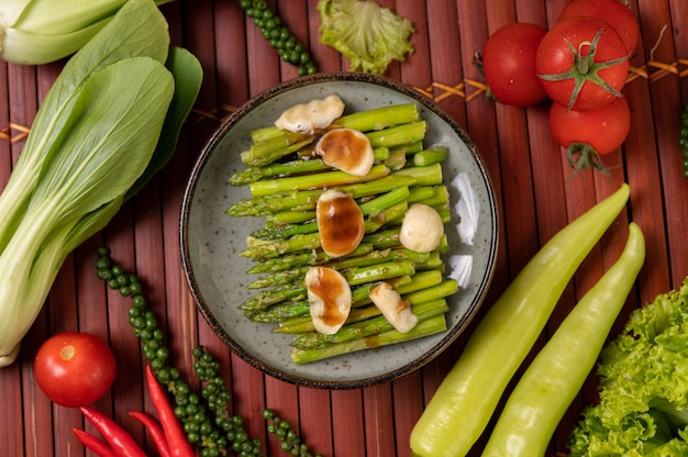 Fried asparagus with oyster sauce in a plate with bell peppers