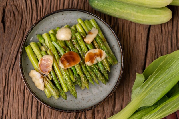 Foto gratuita asparagi fritti con salsa di ostriche in un piatto con peperoni