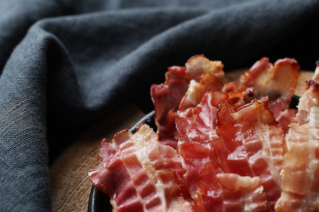 Fried bacon on black plate