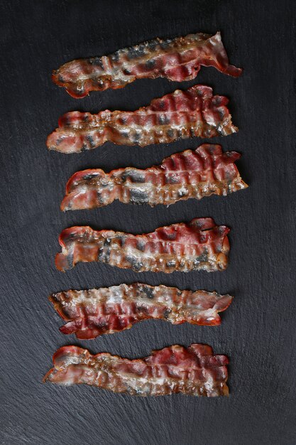 Fried bacon on black stone table