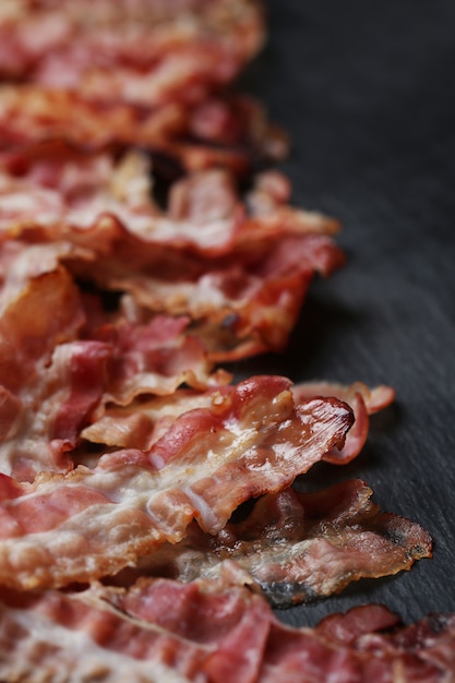 Fried bacon on black table