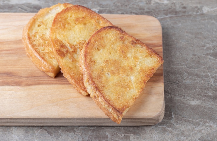 Free Photo fried bread with egg on wooden board.