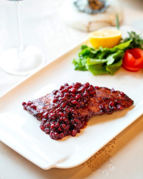 Fried chicken fillet garnished with cooked pomegranate seeds