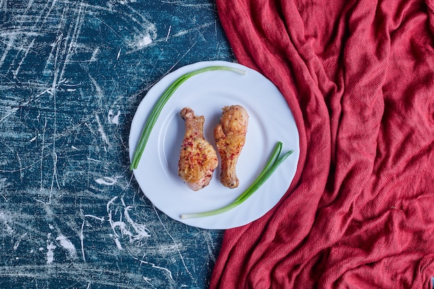 Fried chicken legs in a white plate.