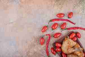 Free photo fried chicken meat in a ceramic platter with chilies and cherry tomatoes.