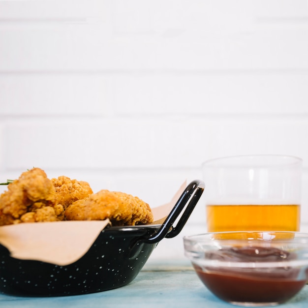 Fried chicken near beer and ketchup